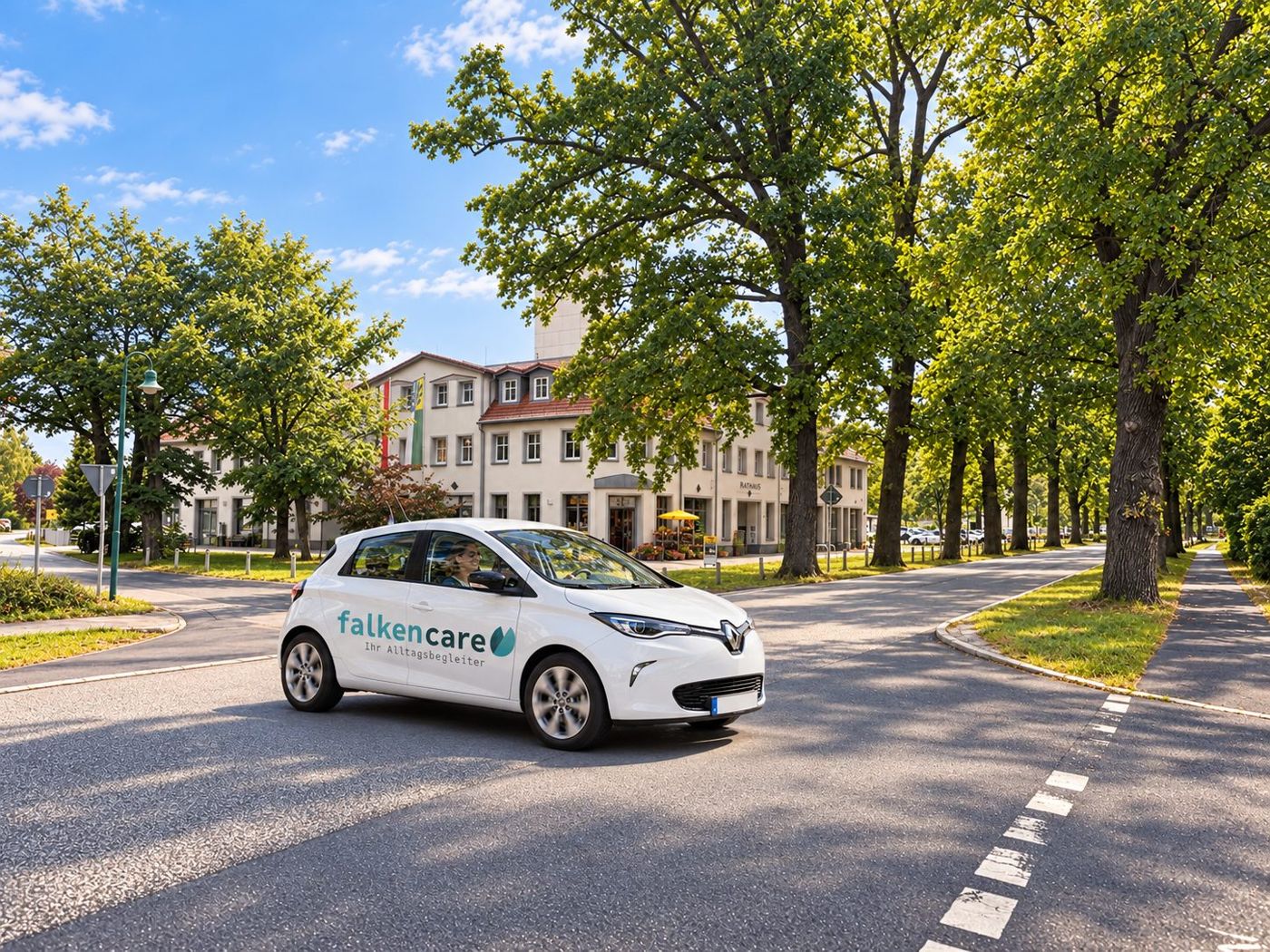 Falken Care unterwegs in Schönwalde-Glien: weißes Dienstauto auf einer Allee im Ortszentrum